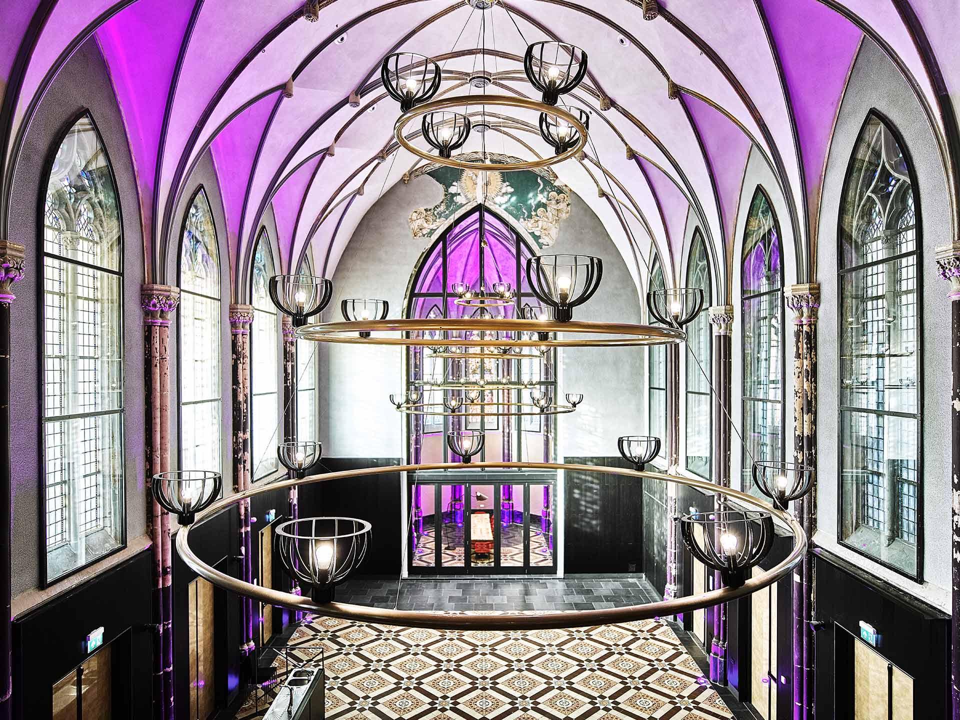Hotel Nassau Breda, elegant ingerichte hall voormalige kerk met luxe decoraties en een sfeervolle ambiance akoestisch spuitwerk.