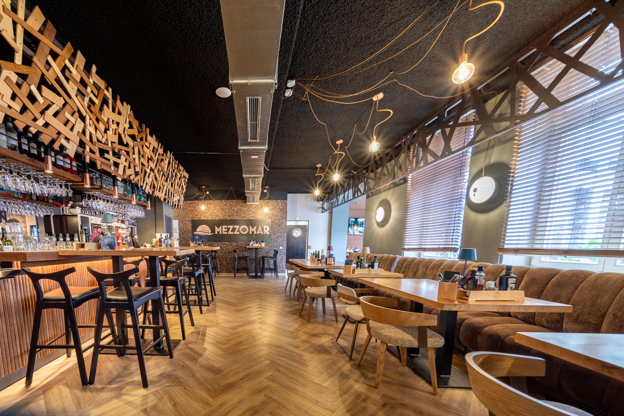 akoestisch spuitwerk plafond restaurant met warme houtafwerking door Acosorb