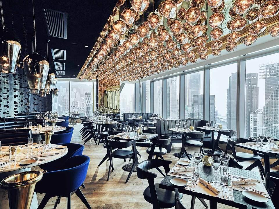 Modern restaurant interior with large windows and city skyline view