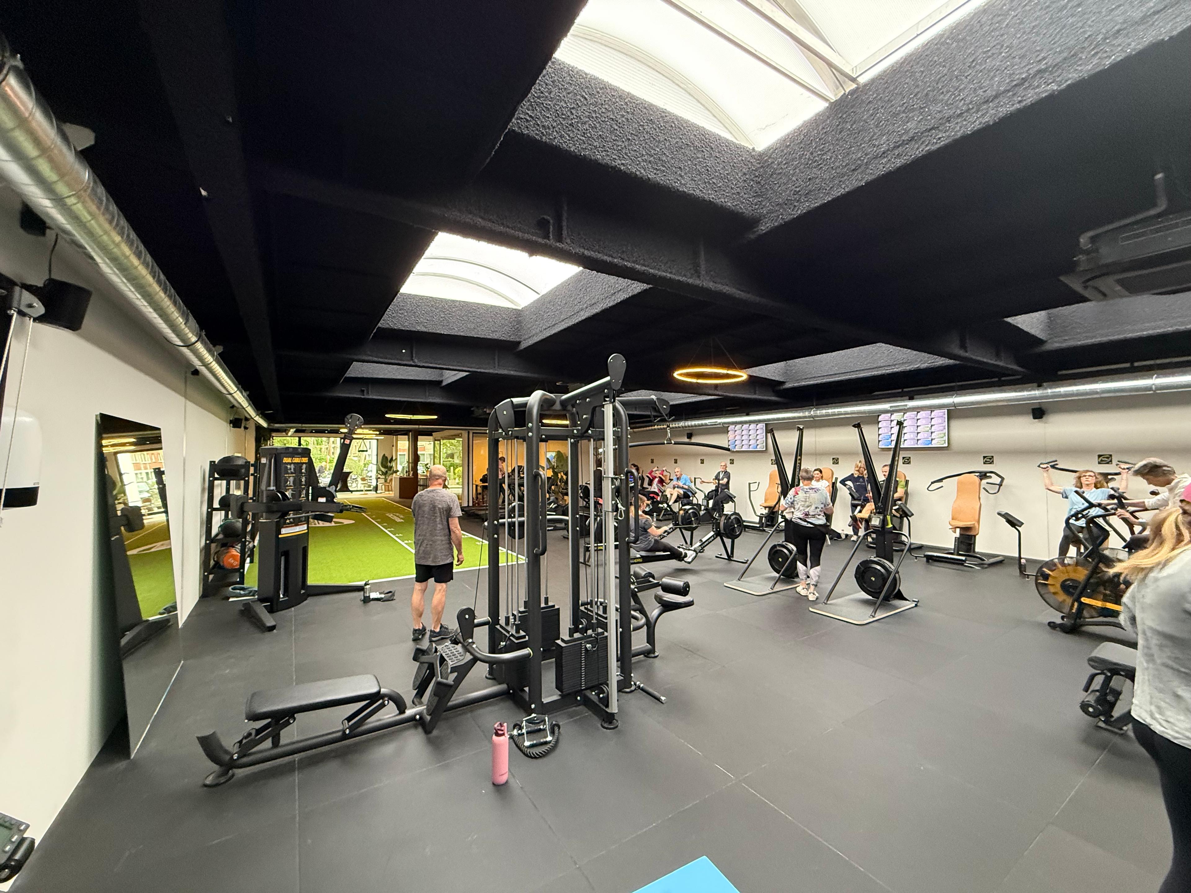 Beweegcoach Brasschaat met Acospray® DC3 in Basic Black aangebracht door Acosorb. Het donkere akoestisch spuitwerk absorbeert galm in de open trainingsruimte en versterkt de premium boutique gym-uitstraling.